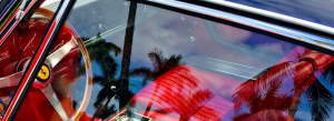 a glimpse into a high end car: a fragment of the steering wheel and a passenger seat