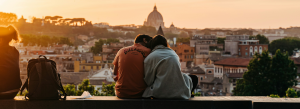 a happy couple enjoying a sunset above a city